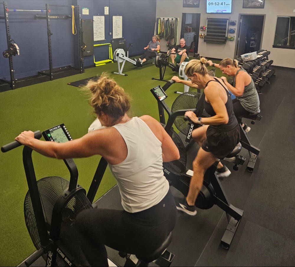 Adults on Echo bikes and rowers during a Pinnacle group class